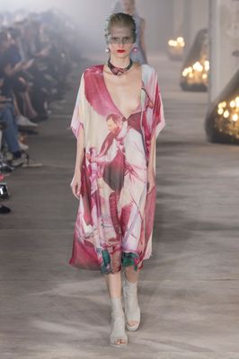 a woman walking down a runway in a dress