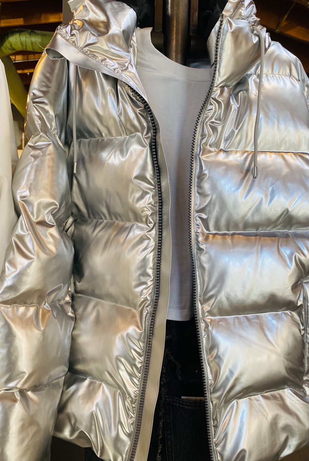a shiny silver jacket hanging on a rack