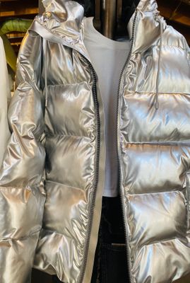a shiny silver jacket hanging on a rack