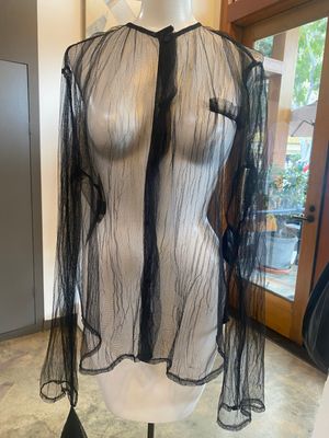 a mannequin wearing a sheer shirt with black lace