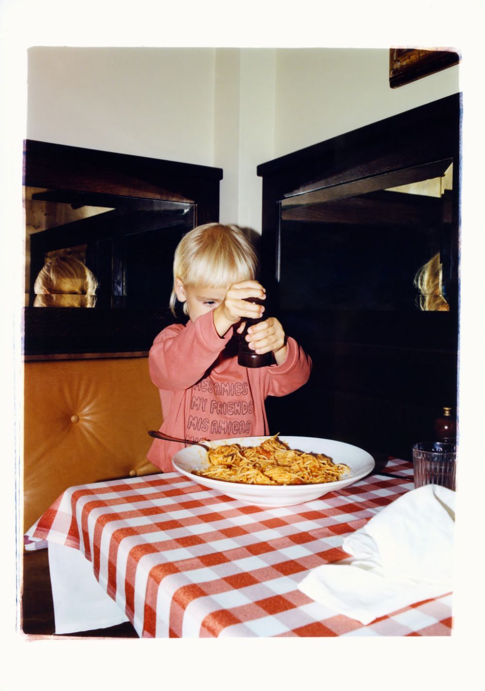 a little boy that is standing in front of a plate of food