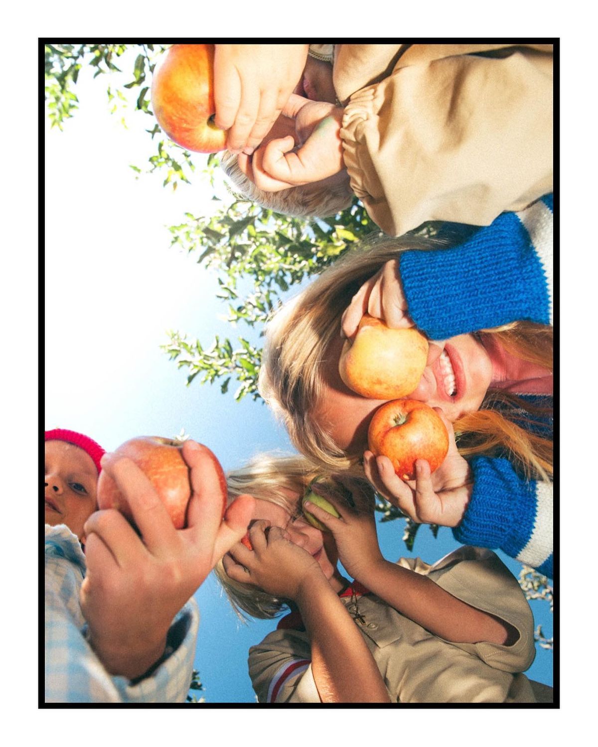 a group of people holding apples in their hands