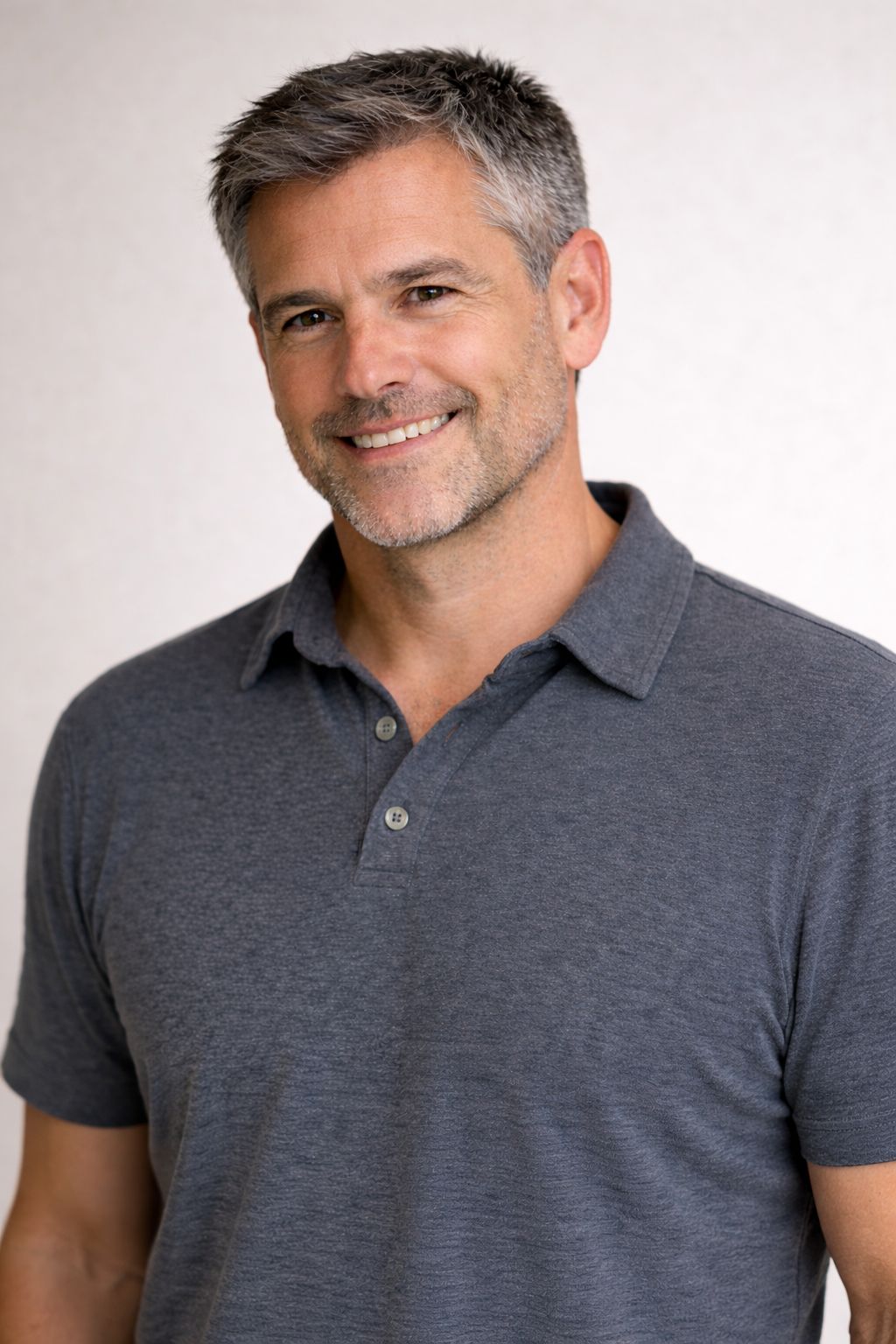 a man in a polo shirt smiling at the camera