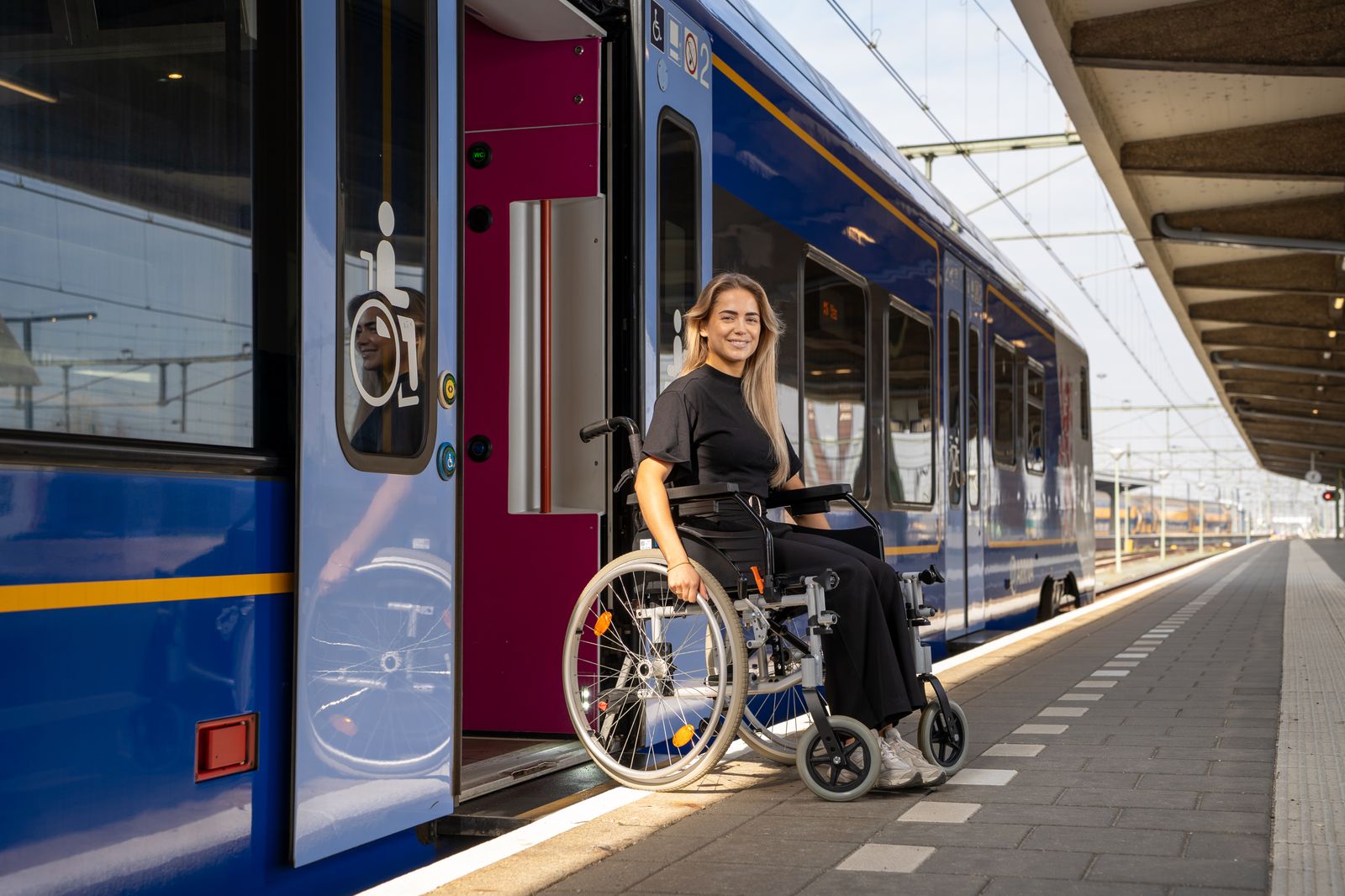 a woman in a wheelchair next to a train