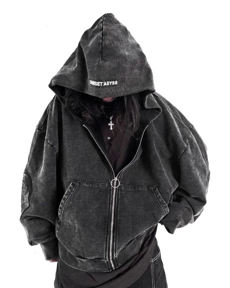 a person wearing a black hoodie with a cross on it