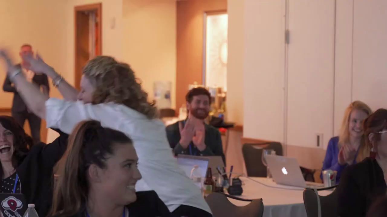 a group of people in a room with laptops