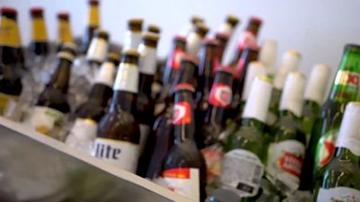 a bunch of beer bottles are lined up on a shelf