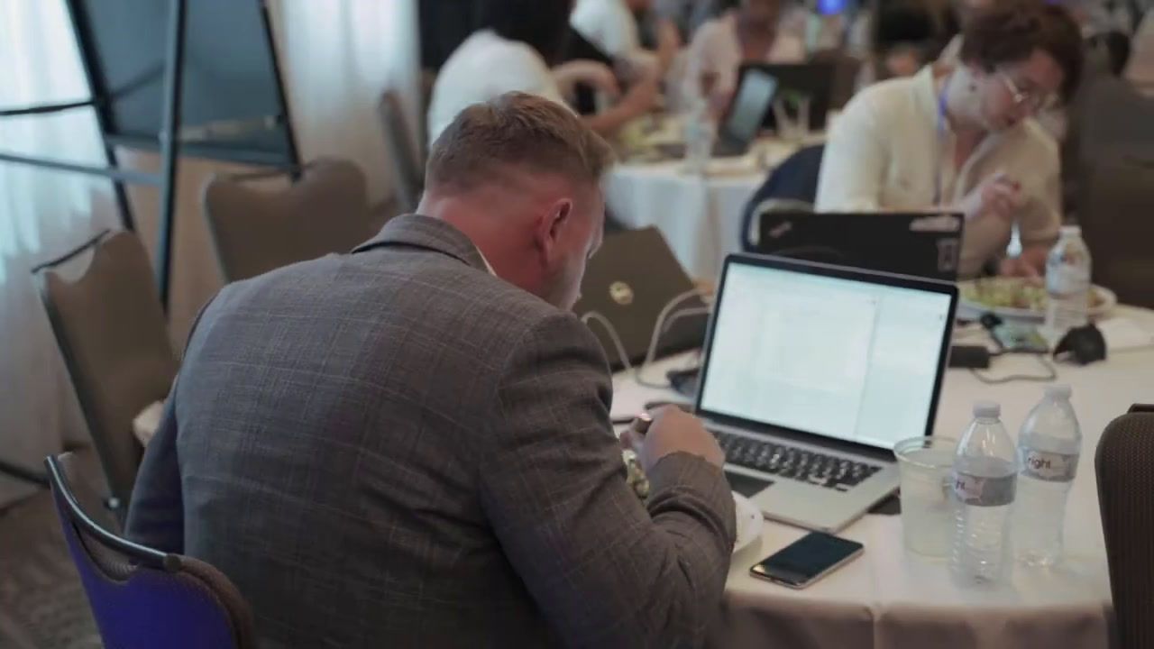 a man sitting at a table with a laptop in front of him