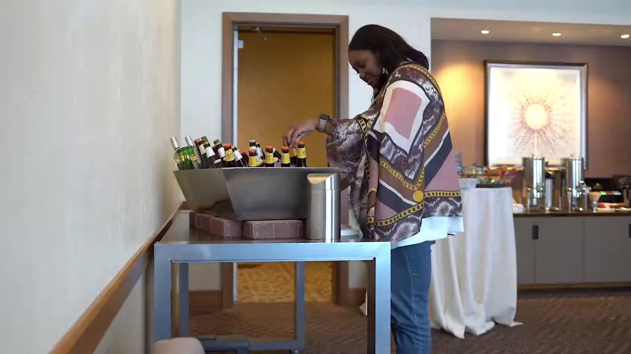 a woman standing at a table with a laptop