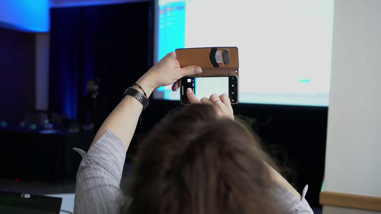 a woman taking a picture of a projector screen