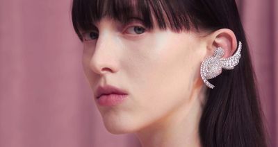 a close up of a person wearing a pair of earrings