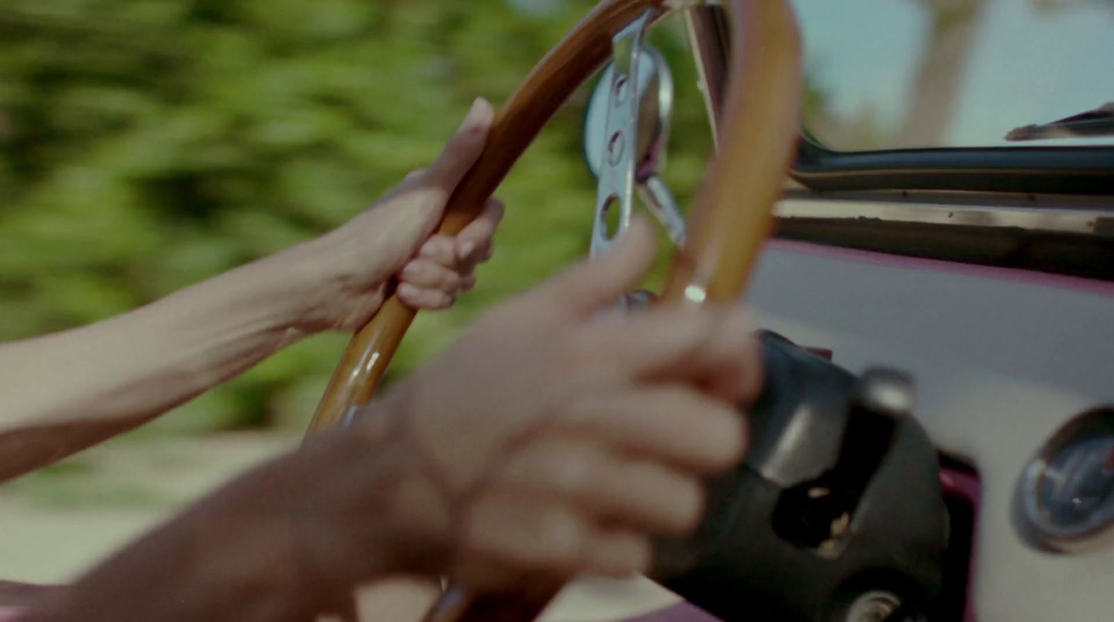 a person holding a steering wheel while driving a car