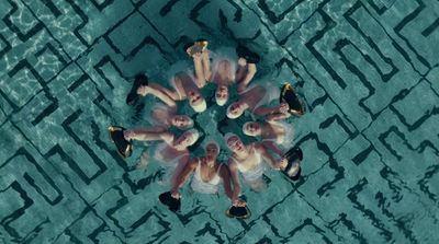 a group of people standing in the middle of a pool