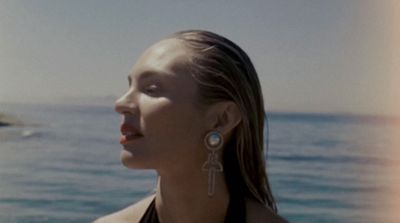 a woman standing in front of a body of water