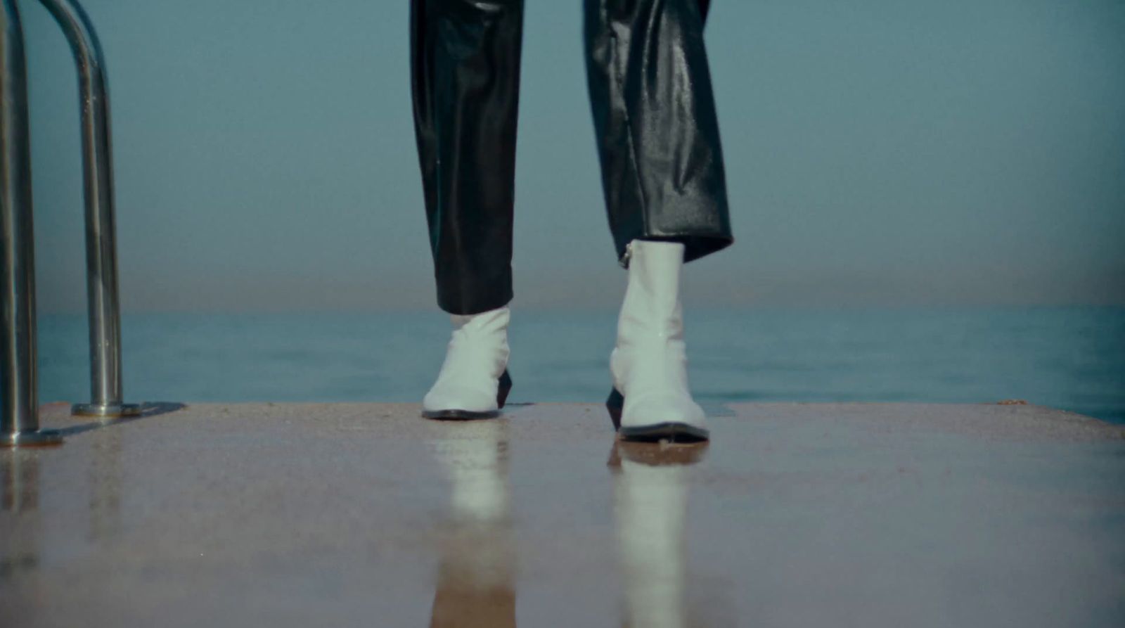 a person wearing white boots and black pants