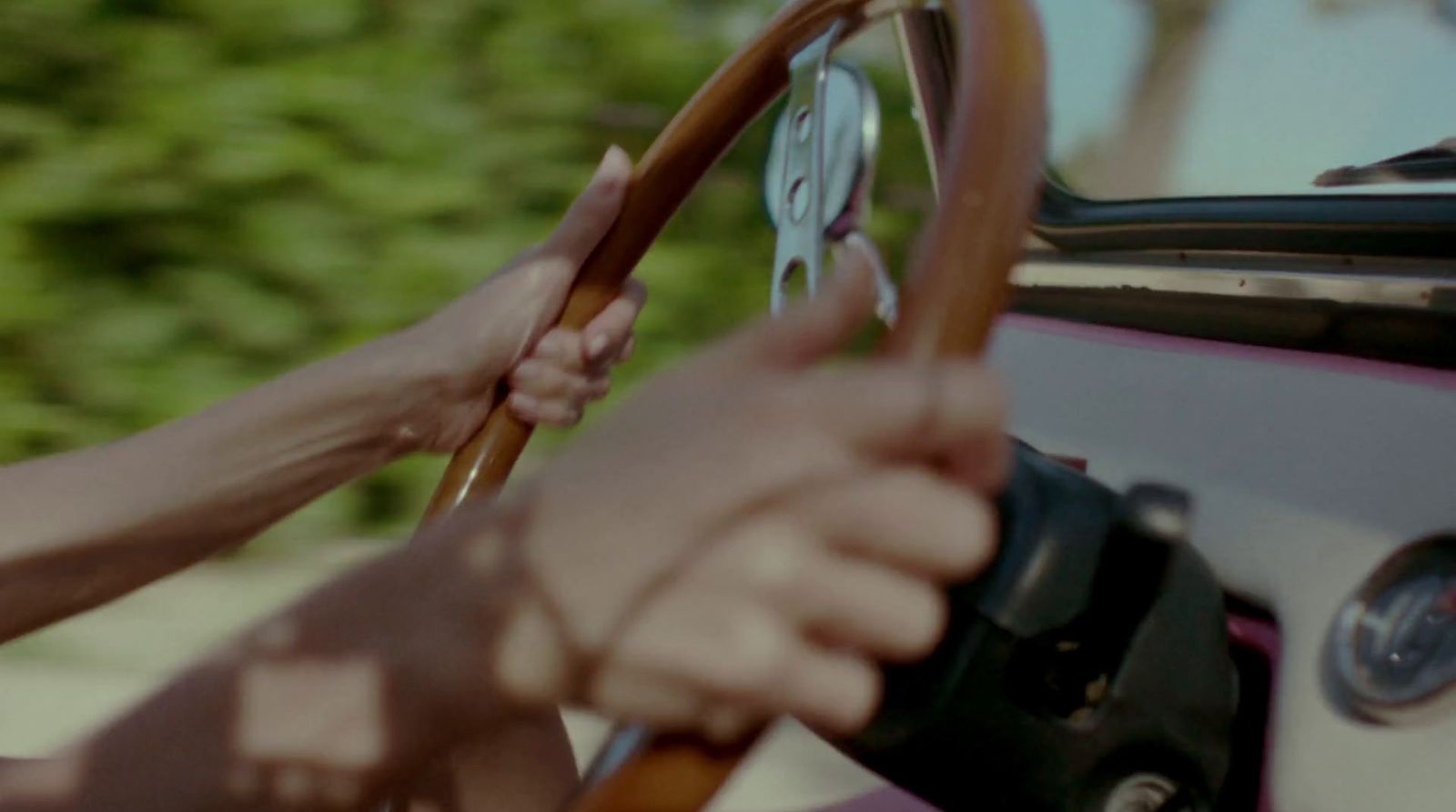 a person holding a steering wheel while driving a car