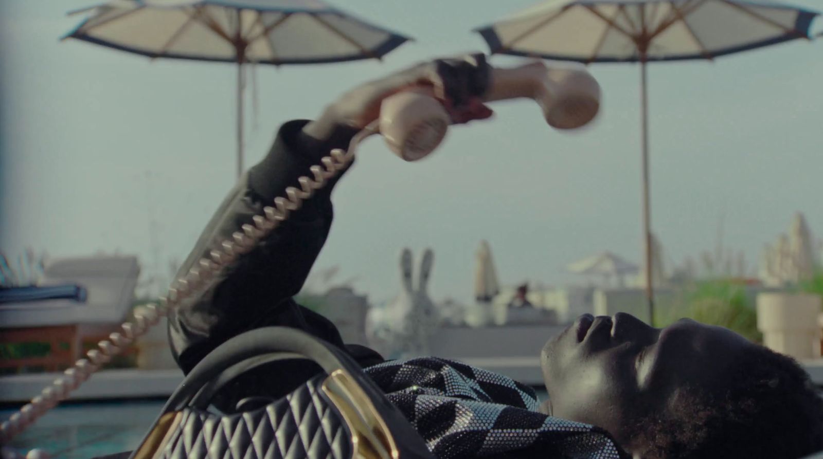 a man laying on top of a beach next to umbrellas