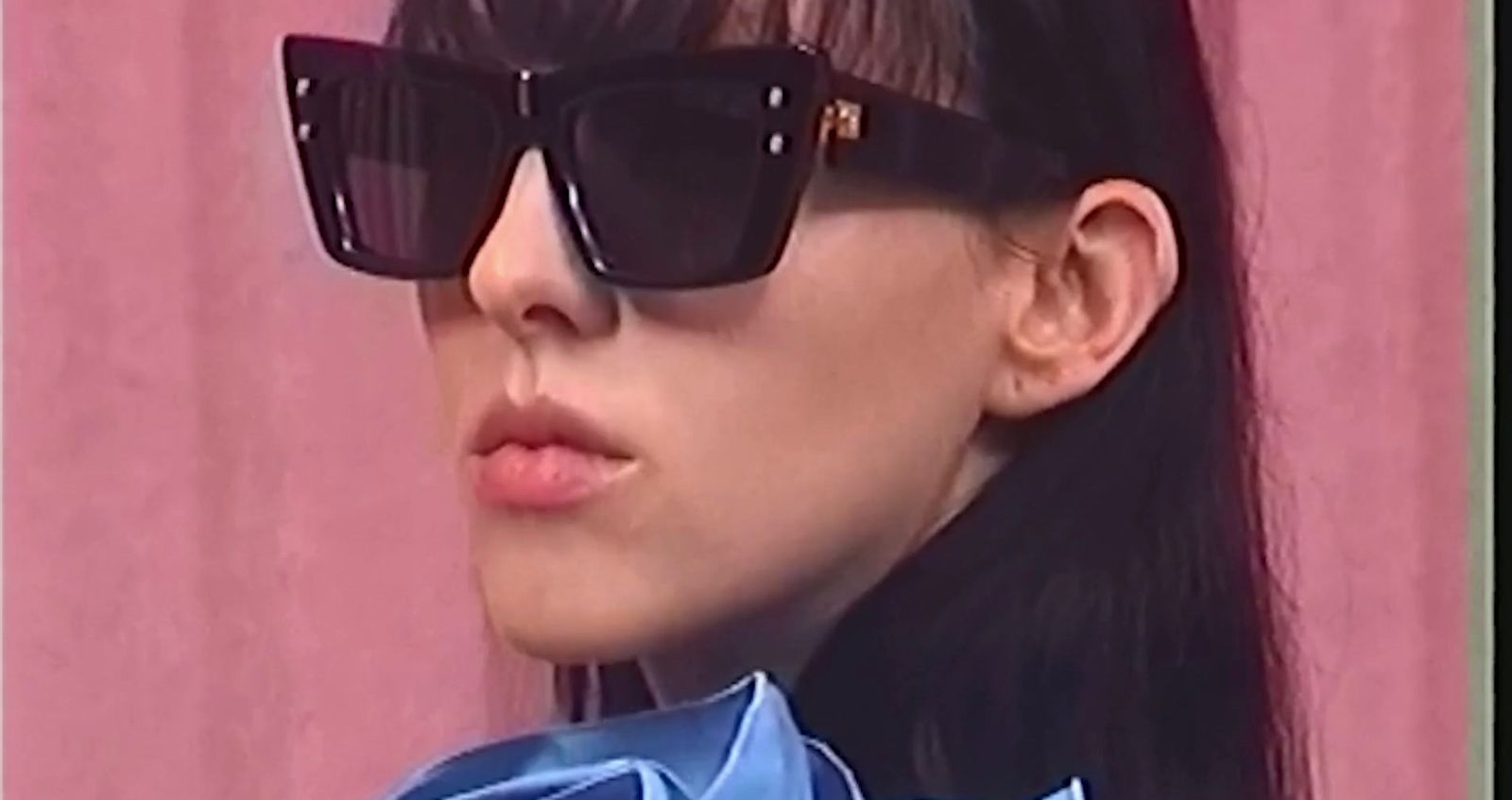 a woman wearing sunglasses and a blue shirt