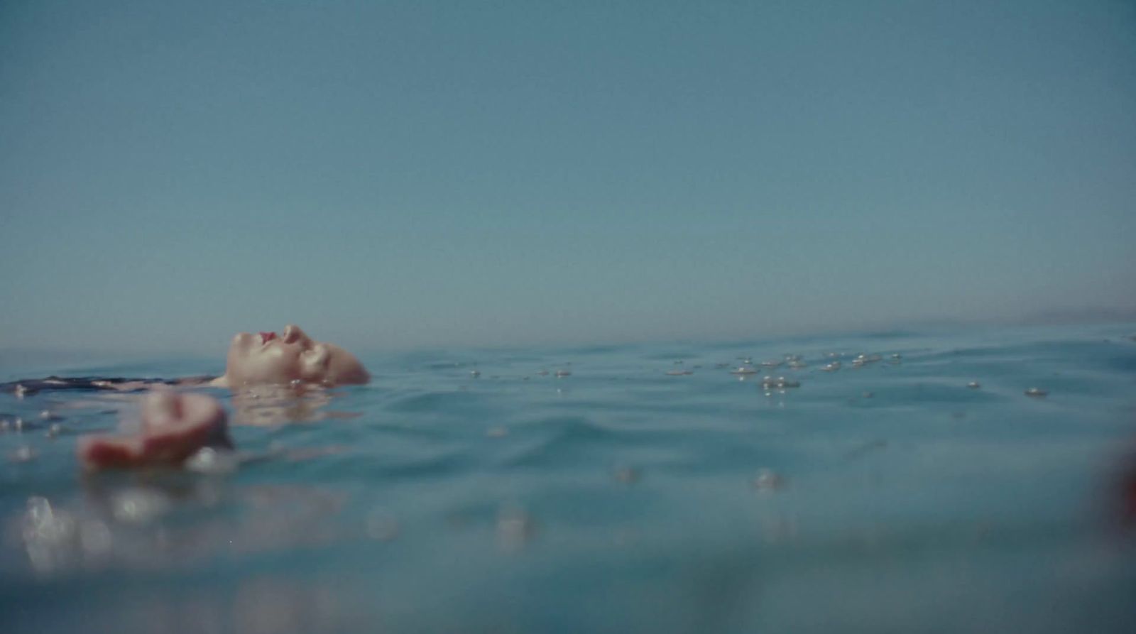 a person floating in the ocean with their head above the water