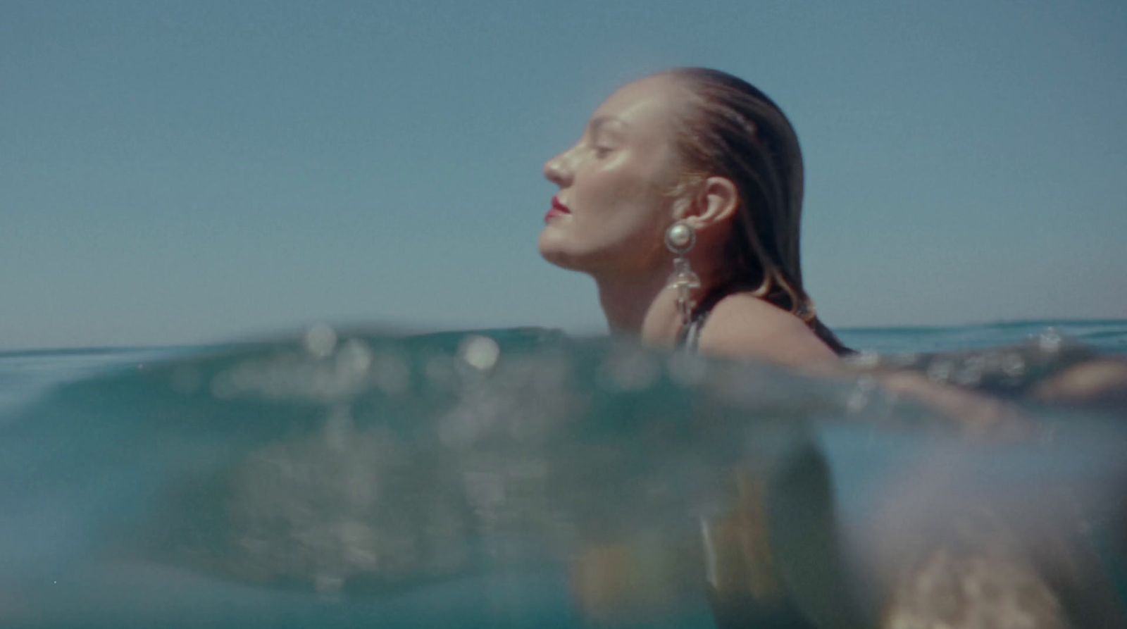 a woman swimming in the ocean with her head above the water