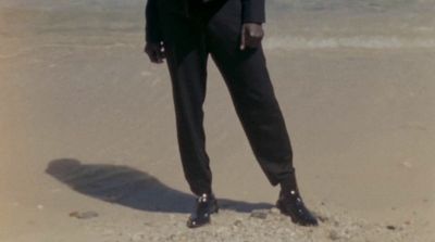 a man in a suit standing on a beach