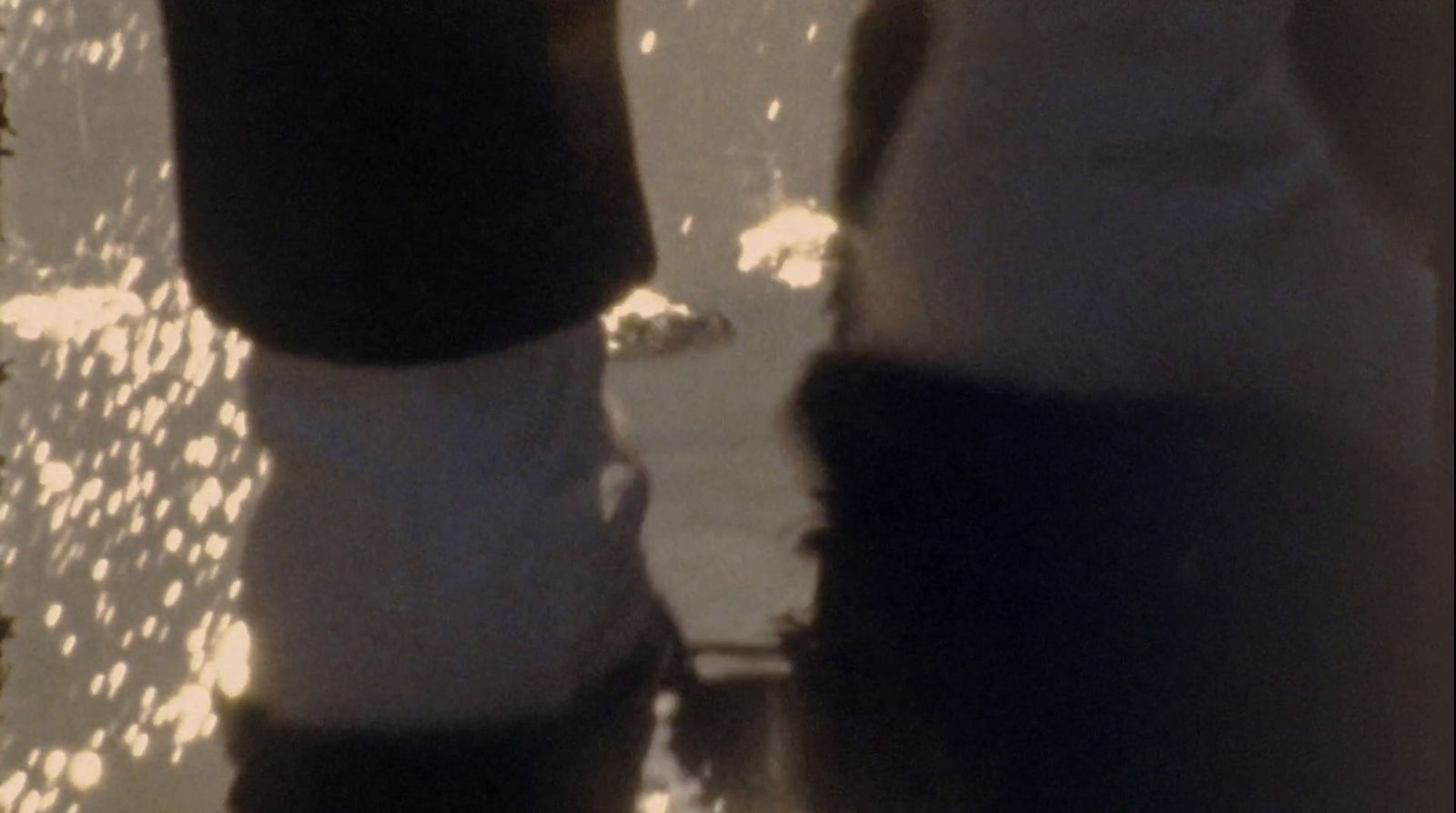 a close up of a person's feet with water in the background