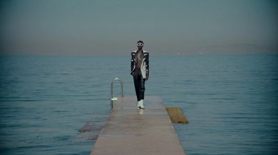 a man is standing on a dock with a surfboard