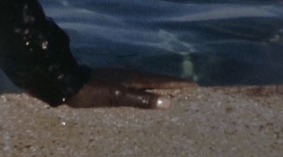 a close up of a person's feet near a body of water