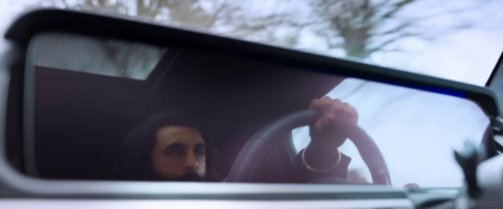 a man sitting in a car holding a steering wheel