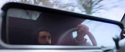 a man sitting in a car holding a steering wheel