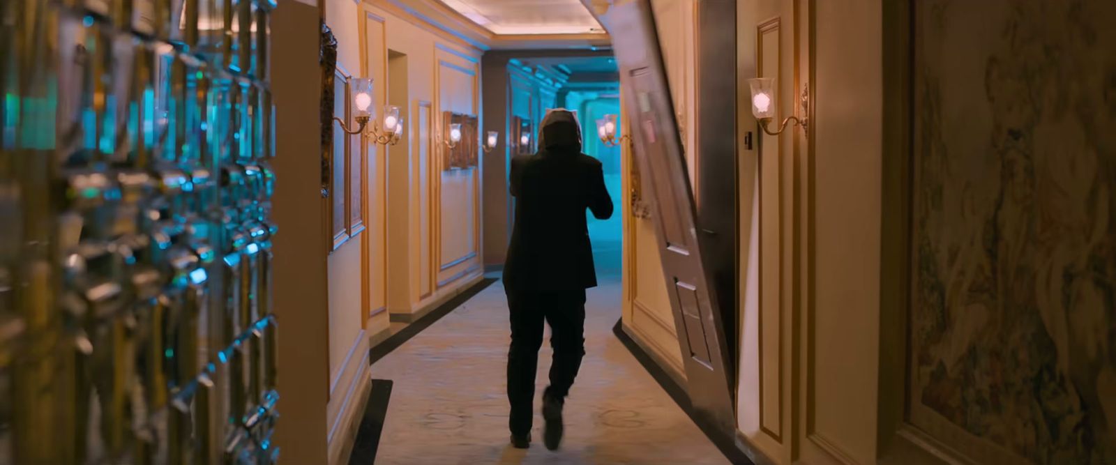 a woman walking down a hallway in a hotel