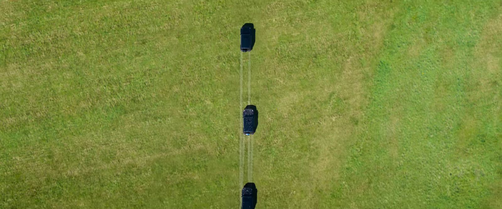 two black umbrellas in the middle of a grassy field