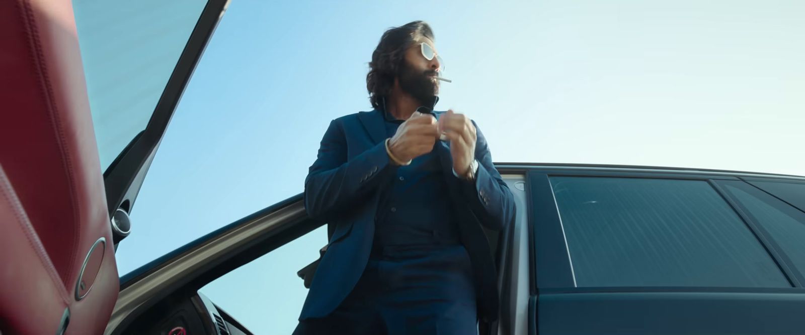 a man in a suit leaning out of a car door