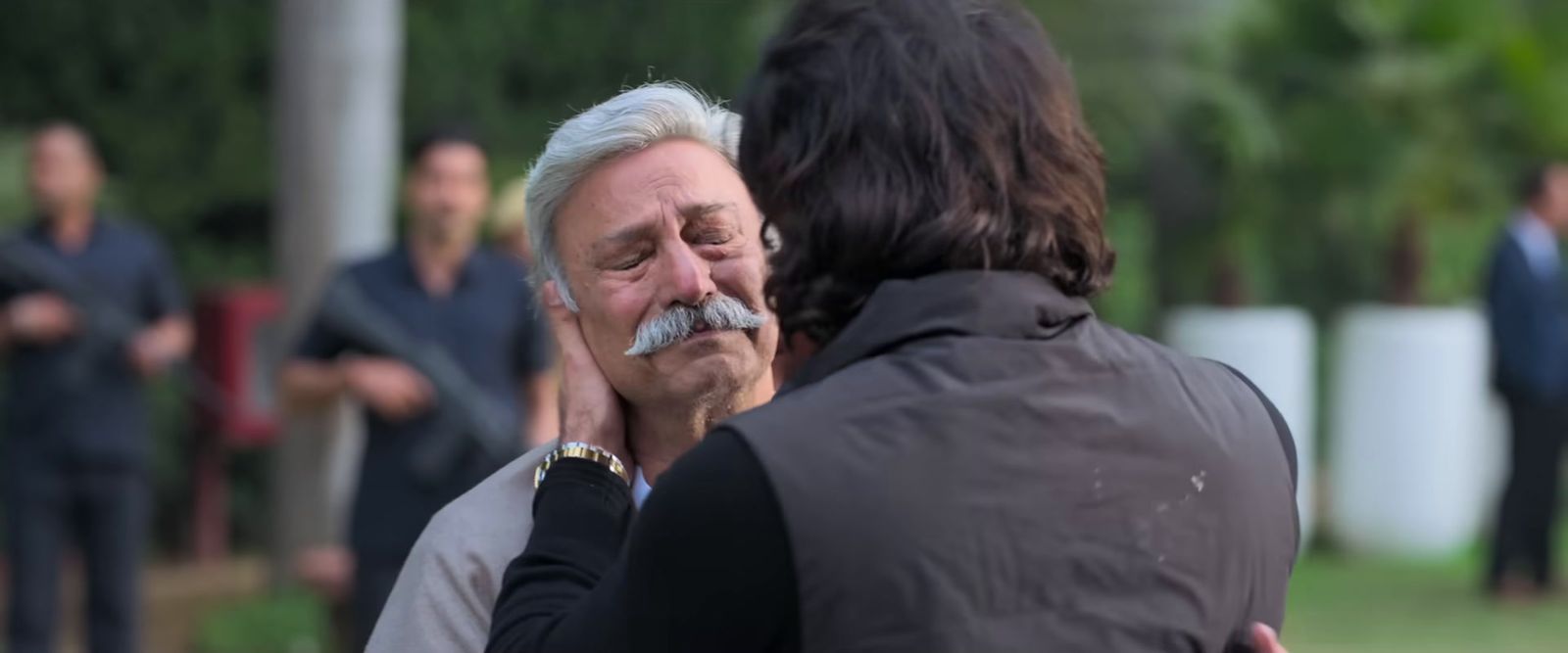 a man with a moustache is talking to a woman