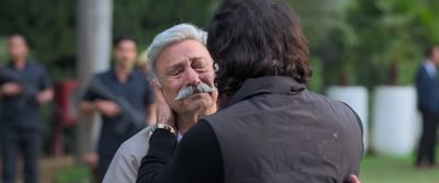 a man with a moustache is talking to a woman