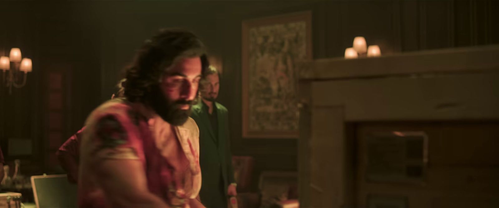 a man with long hair and a beard standing in a kitchen