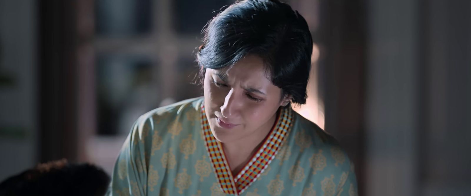 a woman in a kimono looking down at her cell phone