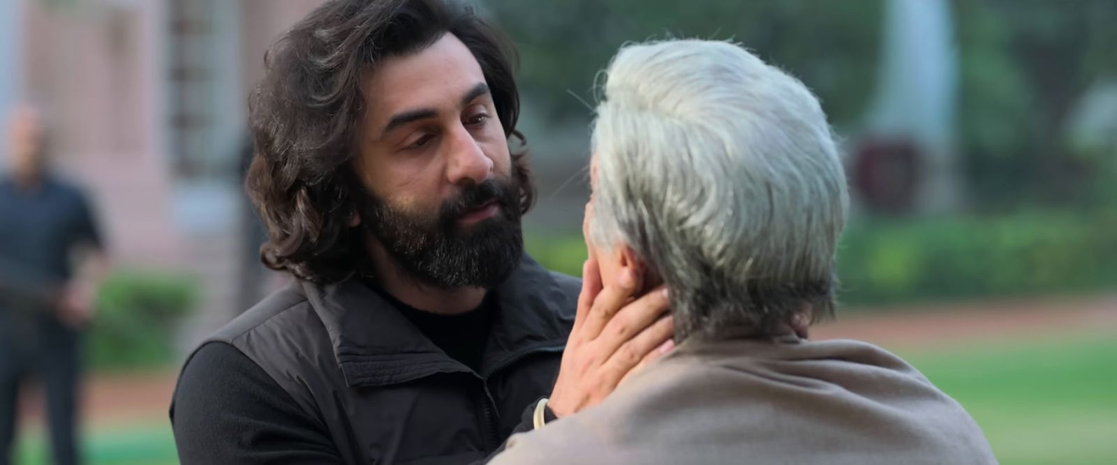 a man with white hair and a beard talking to an older woman