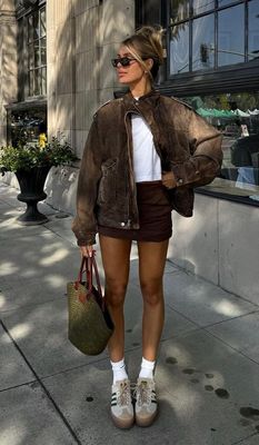 a woman is walking down the street with a handbag
