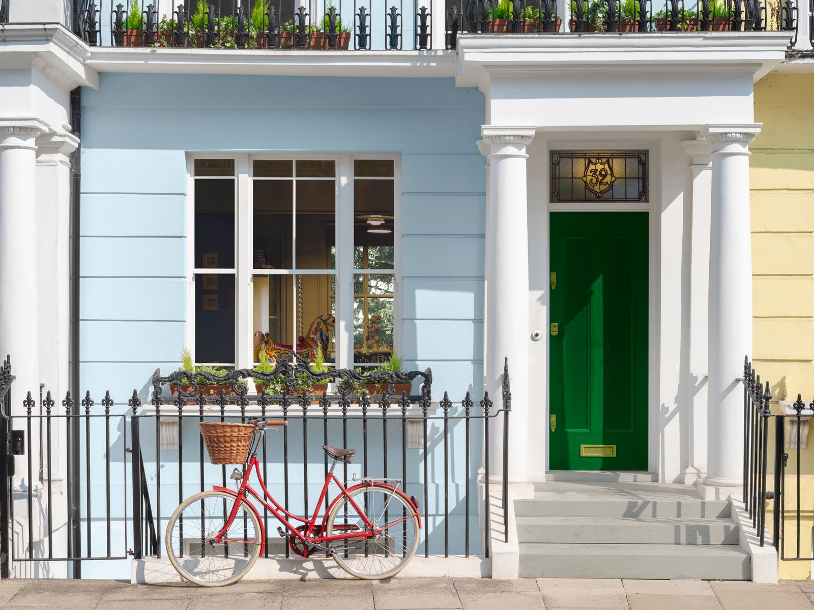 a red bicycle parked in front of a blue building