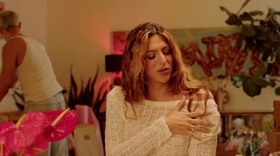 a woman standing in a room holding a wine glass