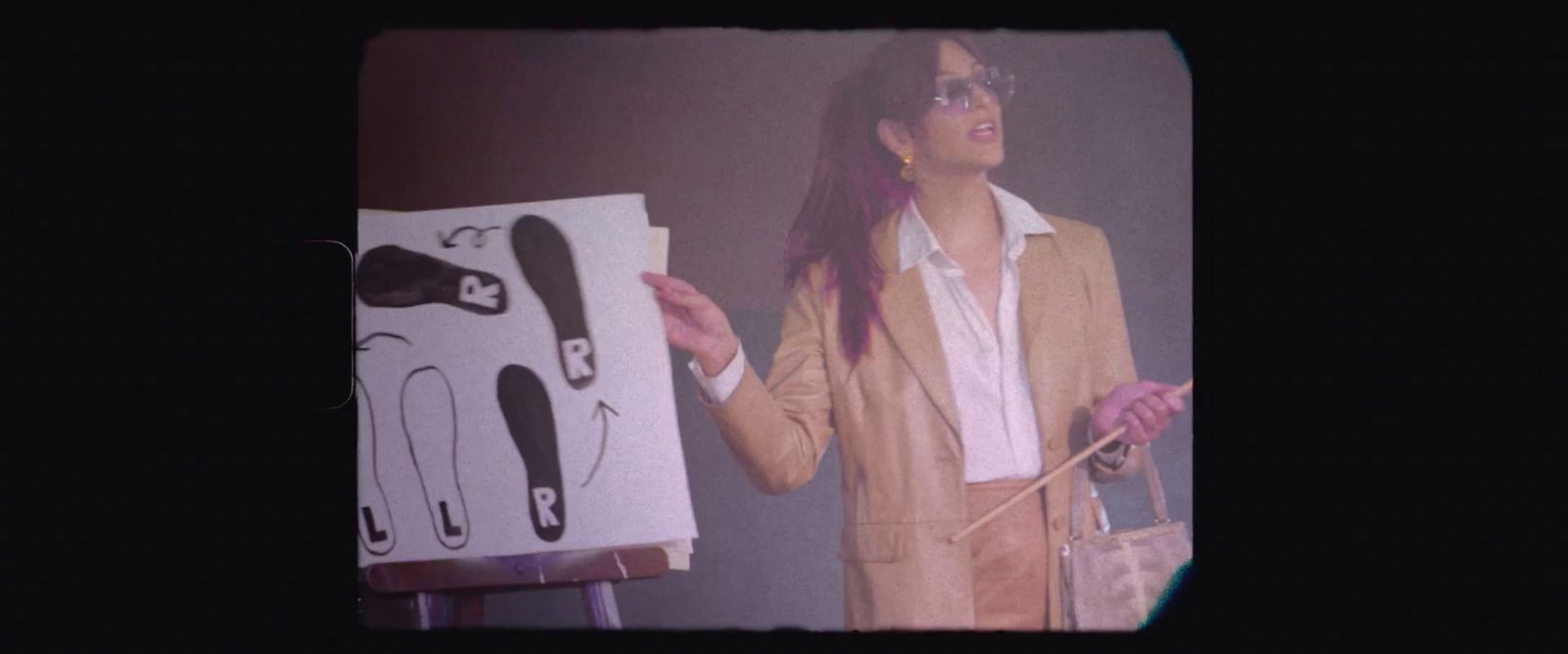 a woman standing in front of a picture of a pair of shoes