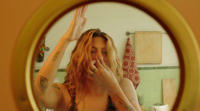 a woman in a bra top brushing her teeth in front of a mirror