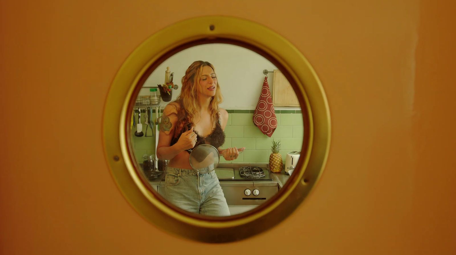 a woman standing in a kitchen in front of a mirror