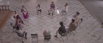 a group of people sitting in chairs in a circle