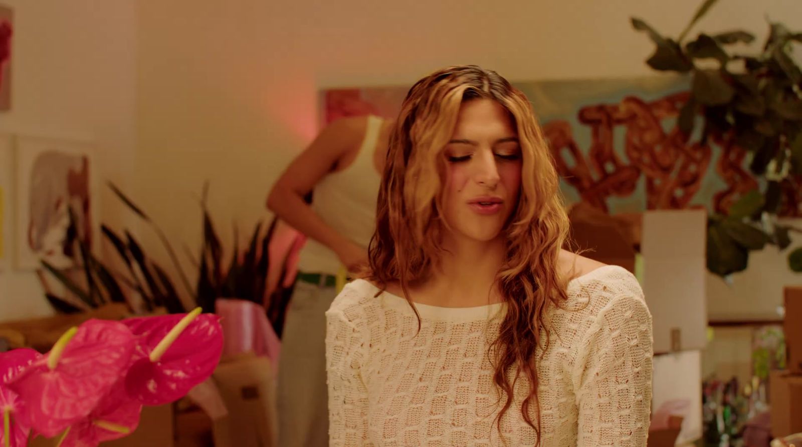 a woman with long hair standing in a room