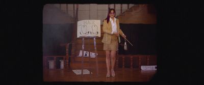 a woman standing on a stage holding a sign