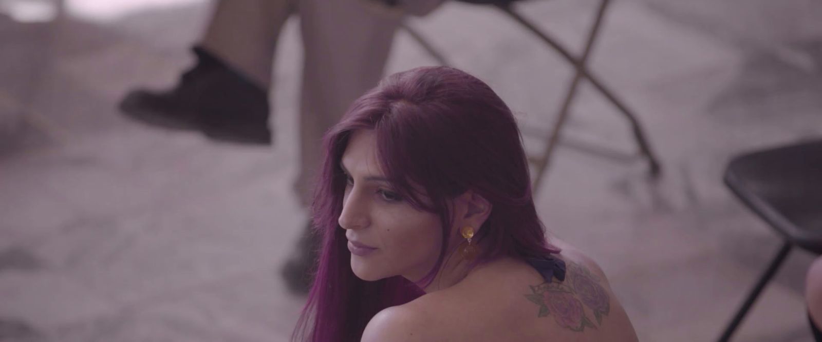 a woman with purple hair sitting in a chair