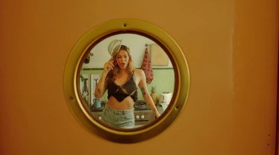 a woman standing in a kitchen in front of a mirror