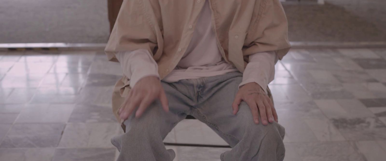 a man sitting on top of a toilet in a bathroom